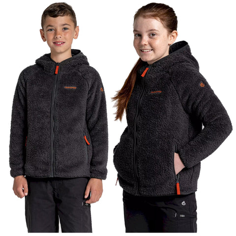 Two children stand side by side wearing dark fuzzy zip-up jackets with hoods and bright zippers. They are smiling in a neutral background suggesting a casual or outdoor context.