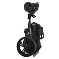 A compact, folded black electric wheelchair stands upright showcasing its rear wheel and remote control attachment in a neutral environment designed for convenience and mobility.