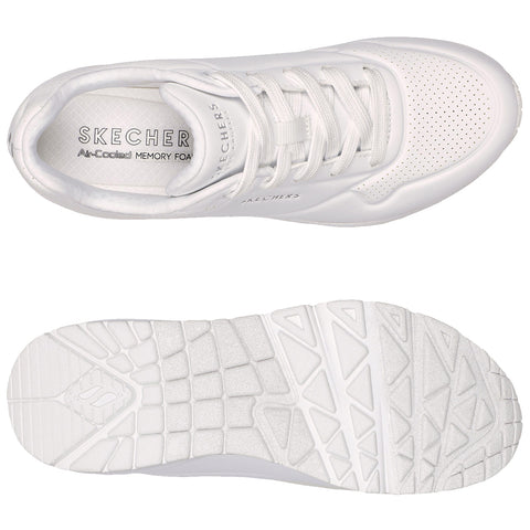 White athletic shoe is positioned with the sole facing down showing a textured pattern while the top displays laces and branding indicating it features air-cooled memory foam for comfort.