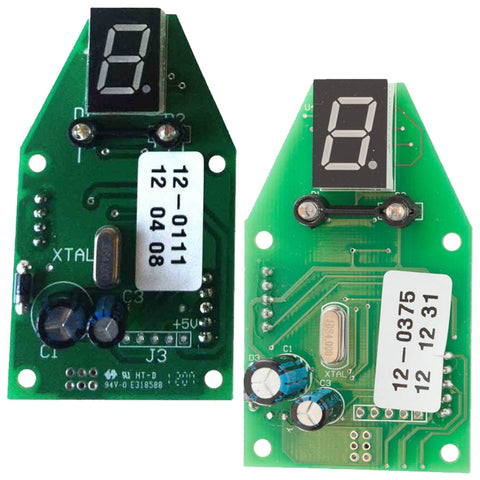 Two green electronic circuit boards are displayed side by side both featuring a numeric display showing the number 8 various electronic components capacitors resistors and labels with numbers and dates.