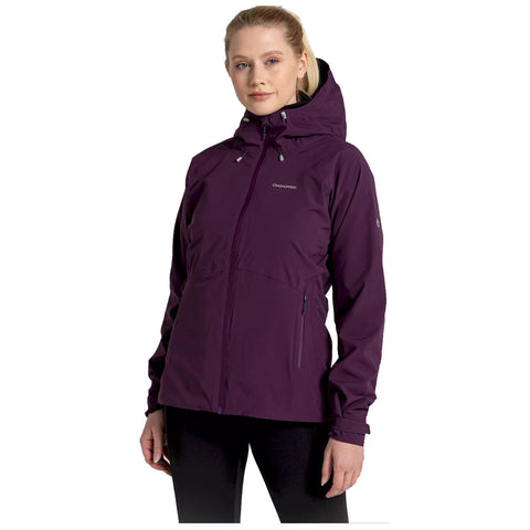 A woman is wearing a purple waterproof jacket with a hood, standing confidently, showcasing the jacket's features, against a plain white background suggesting an outdoor or active context.