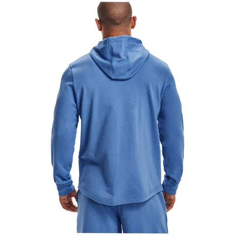 A person wears a blue hooded sweatshirt and matching pants facing away from the viewer in a neutral background emphasizing the clothing and its color.