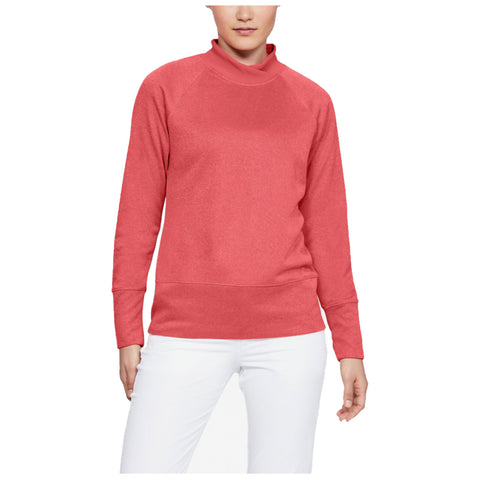 A person wearing a coral-colored long-sleeve pullover with a high neck and white pants stands in a neutral setting, displaying a casual and comfortable style.