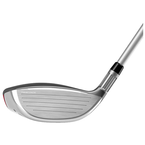 A golf club head with a polished metal face features grooves for striking a golf ball the club is positioned at an angle suggesting readiness for a swing.