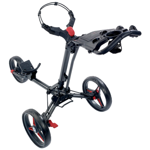 A black three-wheeled golf push cart is positioned upright with a handle and a tray for holding items while the wheels are designed for easy maneuverability on various terrains.