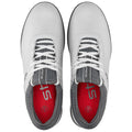 White athletic shoes are positioned with laces neatly tied showing a grey interior and red insoles the shoes are designed for comfort and performance likely in a sporty environment