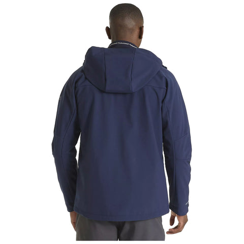 A person wearing a navy blue jacket with a hood stands with their back turned in a neutral setting, suggesting they are either outdoors or in a casual environment.