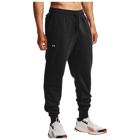 Black jogger pants are worn by a person with their back facing the viewer while standing. The setting appears neutral with no specific context provided. The individual wears white athletic shoes.