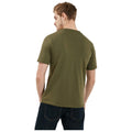 A person with short hair is wearing an olive green t-shirt and dark jeans standing with their back facing the viewer in a plain white background.