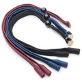 Colored fabric cords lie flat, with ends coated in various colors. Smooth beads and small tags are attached, suggesting use for fastening or decorative purposes in a textile context.