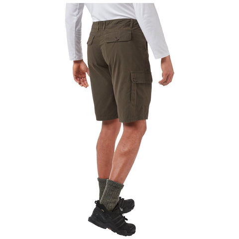 A person stands with their back facing the viewer wearing olive green cargo shorts and black shoes with green patterned socks showing. The setting appears neutral and unobtrusive.