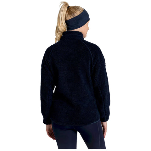 A person is wearing a dark fleece pullover and a matching headband while facing away from the viewer in a simple background, suggesting a casual or active setting.