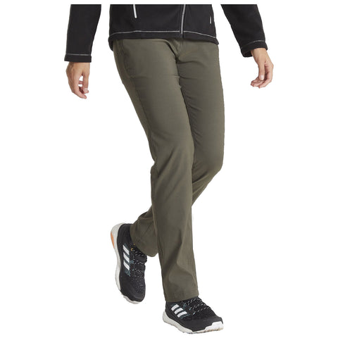 A person is walking while wearing olive green pants and black athletic shoes with white stripes in a casual setting, suggesting an active or outdoor environment.