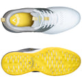 A white and gray athletic shoe with yellow detailing sits on a flat surface showcasing its top and sole views highlighting design features and logo placement.