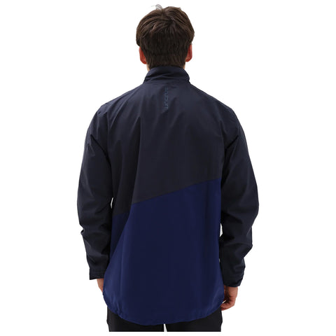 A person wears a dark navy jacket standing with their back facing the viewer in a plain backdrop suggesting an outdoor or casual setting.