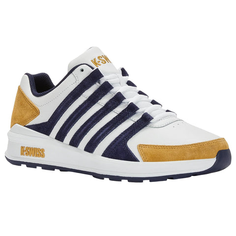 A white sneaker with navy and mustard accents sits on a flat surface showcasing a sleek athletic design with several white stripes and a branded logo on the side.