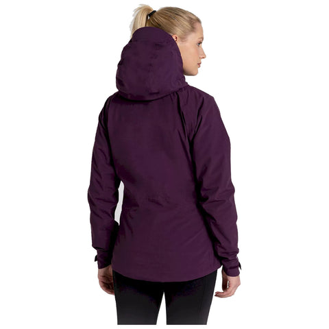 A woman wears a purple hooded jacket while facing slightly to the side in a simple background suggesting an outdoor context. She has a ponytail and appears to be in a casual setting.