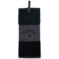 A black golf towel hanging vertically features a textured top with a honeycomb pattern a middle section with a gray background and the Callaway logo and a solid black bottom portion.