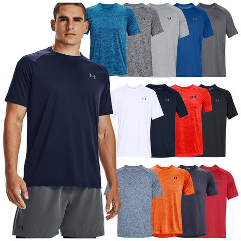 A male model stands in athletic shorts displaying a collection of colorful t-shirts hanging beside him in various styles and colors against a plain backdrop showcasing activewear options.