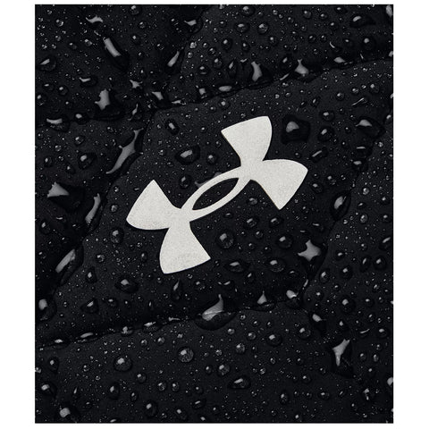 Black fabric with a prominent white logo is covered in numerous water droplets giving a sense of moisture and texture in an outdoor or damp environment.