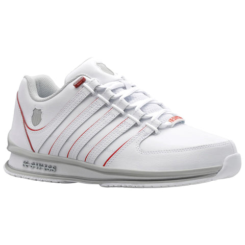 A white athletic shoe with red accents is positioned prominently. It features a textured upper and laces, designed for performance. The shoe is set against a plain background.