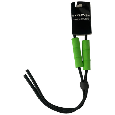 Eyewear retainers are displayed hanging from a tag. The retainers are primarily black with two green rubber grips for comfort and grip. They are designed to hold glasses securely.