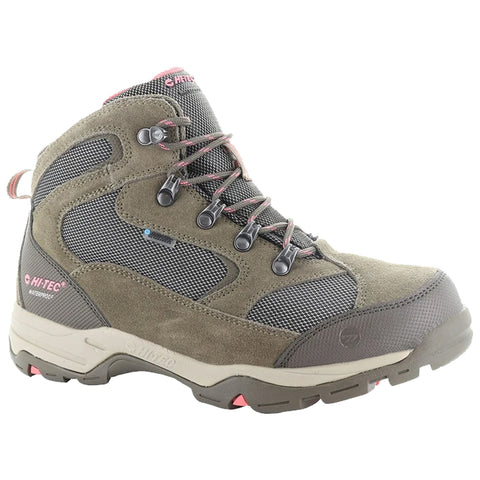 A hiking boot is positioned upright showcasing a mix of textured brown suede and black mesh materials the boot features metal eyelets and a prominent rubber sole indicating durability for outdoor activities