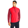 A man wearing a bright red half-zip athletic shirt with textured sleeves stands confidently against a plain white background, showcasing casual sportswear style.