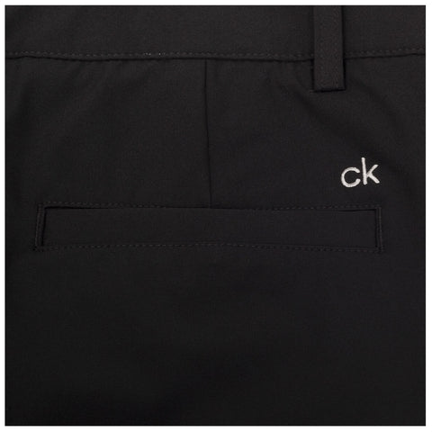 Black pants are displayed with a clean design featuring a small embroidered logo on the side and a pocket that has a horizontal opening without visible embellishments or patterns.