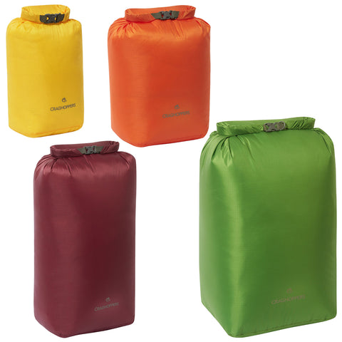 Colorful dry bags are displayed upright with their tops rolled down and secured. Each bag is a different color—yellow, orange, green, and maroon—showcasing a variety of options for outdoor use.