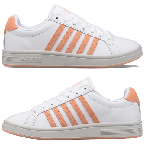 White sneakers are displayed showing a clean design with orange stripes and heel accents while resting on a neutral background highlighting their sporty aesthetic.