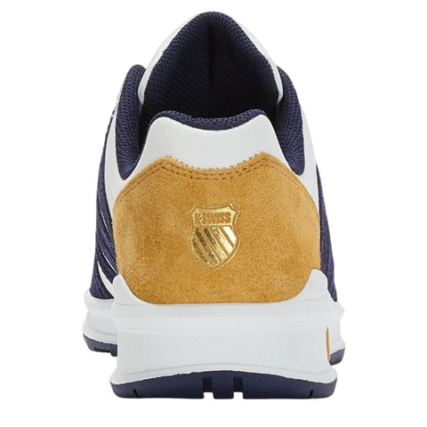 Navy and white sneaker with a golden emblem on a suede heel features a textured design and a cushioned sole positioned against a plain background.