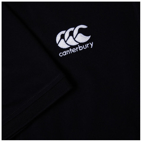 A black garment features an embroidered logo of three stylized waves along with the word "canterbury" below it, on a textured fabric background. The focus is on the logo and sleeve detail.