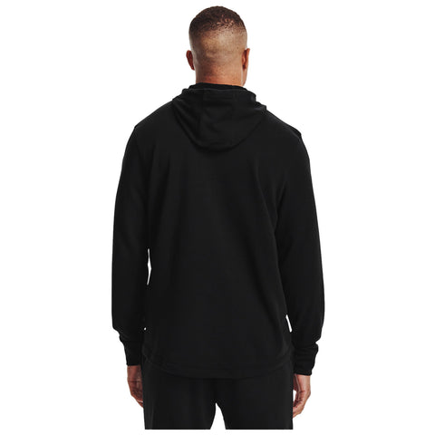 A person is standing with their back facing the viewer wearing a black hooded sweatshirt in a neutral background emphasizing the simplicity and comfort of the outfit.