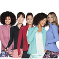 Five women stand together wearing various colorful jackets while smiling and posing confidently. The background is plain white, emphasizing their outfits and expressions. They exhibit joy and style.