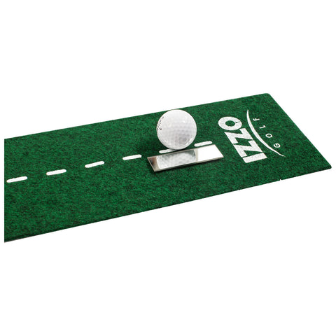 A golf ball rests on a green putting mat with a reflective surface. The mat features dashed lines and the logo for Izzo Golf, suggesting a practice setup for golfers.