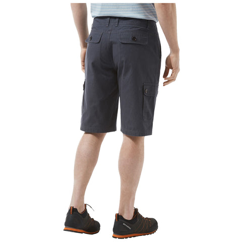 A person is standing with their back facing the viewer wearing dark cargo shorts and black shoes with orange accents in a plain white background.