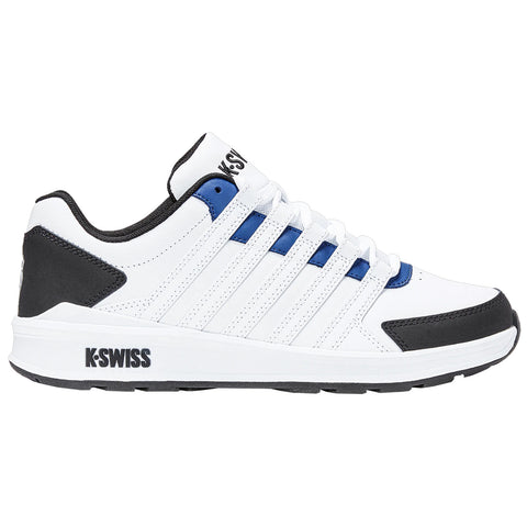 A white athletic shoe is displayed with blue and black accents while sitting on a flat surface showcasing its sleek design and brand logo on the side.