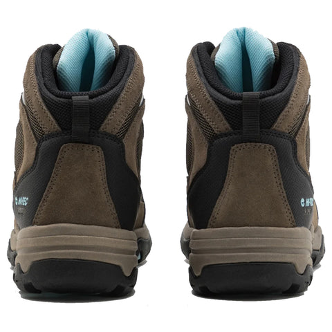 Two hiking boots are displayed standing upright with a focus on the back view featuring a dark brown suede exterior and black mesh panels against a light blue padded collar.