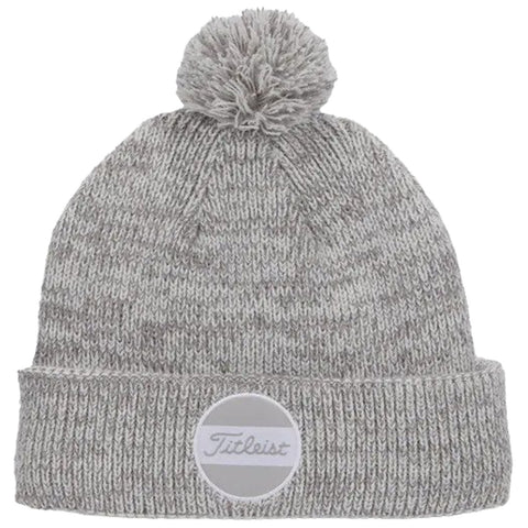 A gray knitted beanie with a pom-pom on top is displayed prominently The beanie features a white circular patch with the brand name Titleist on the front