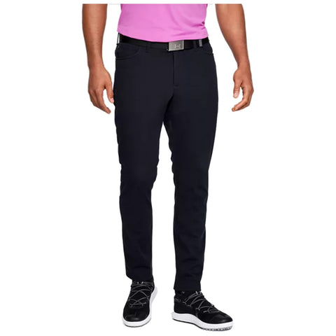 A person wearing black pants and black athletic shoes stands upright with hands at their sides The individual is also wearing a bright pink shirt and a black belt