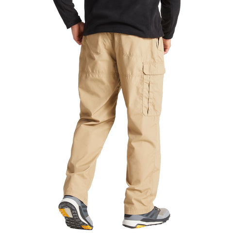 A person is standing with their back to the viewer wearing khaki cargo pants and gray athletic shoes the setting appears to be indoors with a plain background