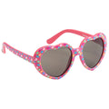 Heart-shaped sunglasses are displayed resting on a surface showcasing bright pink frames adorned with colorful hearts and dark lenses suitable for sunny environments.