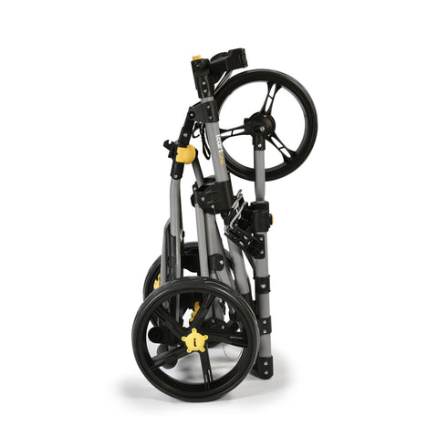 A folded stroller stands upright showcasing its compact design with black wheels and a gray frame featuring yellow accents in a plain white background.