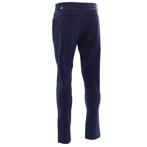 Navy trousers are displayed upright with a focus on the back view showcasing two back pockets and a sleek fit in a plain backdrop.