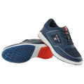 Two athletic shoes are positioned with one slightly elevated above the other showcasing their design and colors. The shoes are primarily navy blue with white accents and textured soles.