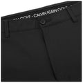 Black pants are displayed flat with a button and zipper at the front the label reads CALVIN KLEIN GOLF suggesting the garment is designed for sportswear or casual occasions.