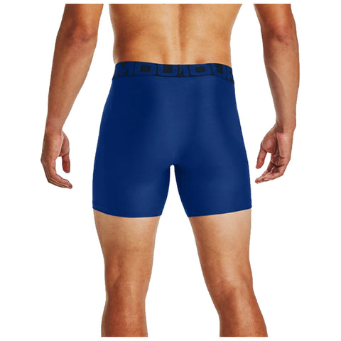 A person stands with their back facing forward wearing form-fitting blue athletic shorts with a black waistband featuring the word "MOULOU" visible across the top