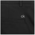 A pair of black pants is displayed with a small embroidered logo "ck" on the front pocket area the fabric appears smooth and tailored suggesting a stylish and modern design.