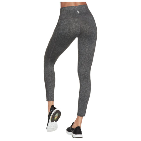 Black high-waisted leggings are being worn by a person facing away from the viewer while standing in athletic shoes on a neutral background.